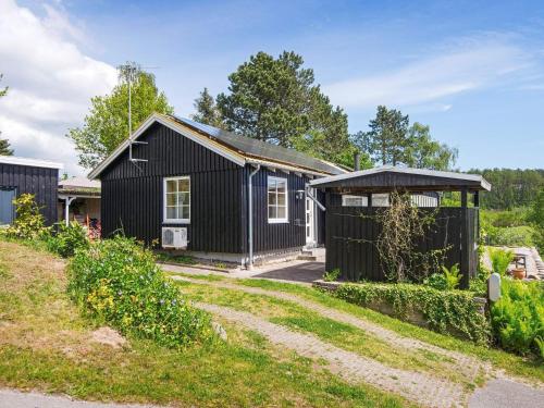 uma casa preta com um telhado preto em 8 person holiday home in Ebeltoft em Ebeltoft