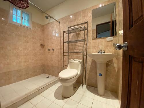 e bagno con servizi igienici, lavandino e doccia. di Hostal Lopez El Valle Cabañas a El Valle de Antón