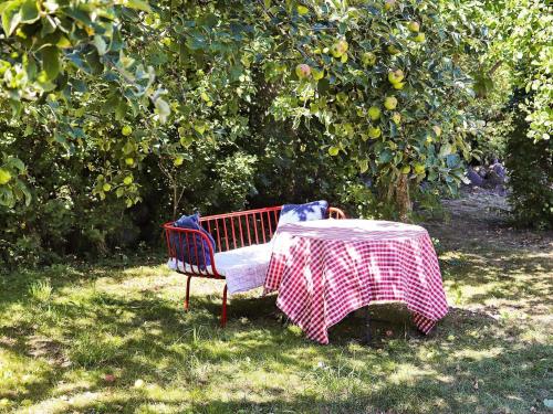 a bench with a table in an apple tree at 10 person holiday home in L DERUP in Löderup