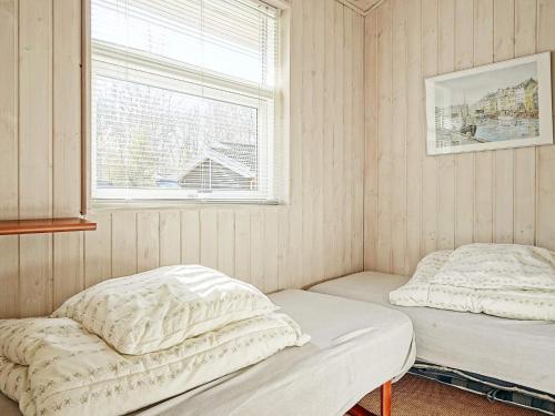 Four-Bedroom Holiday home in Hasle 1 في Hasle: سريرين في غرفة مع نافذة