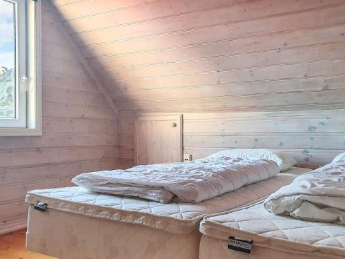 two beds in a room with wooden walls at 9 person holiday home in Utsira-By Traum in Utsira