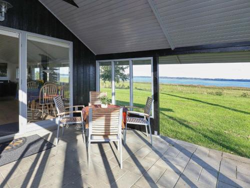 a screened in porch with a table and chairs at 4 person holiday home in H jslev in Højslev
