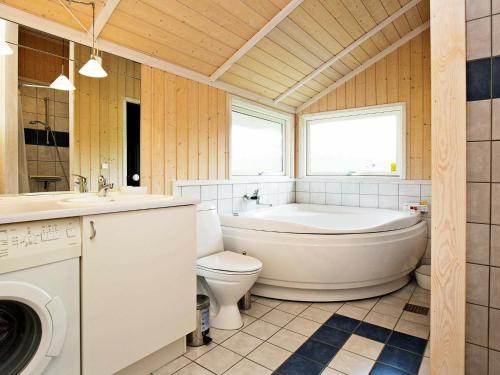 a bathroom with a tub and a toilet and a sink at 7 person holiday home in Asn s in Asnæs