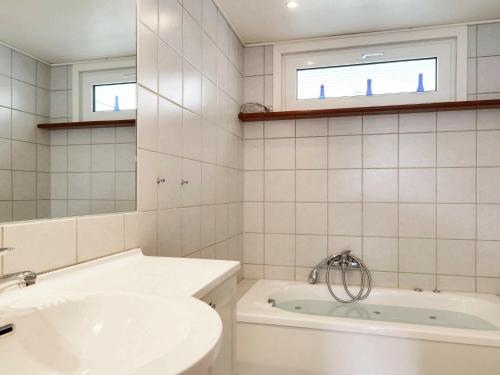 Baño blanco con bañera y lavamanos en 6 person holiday home in Hemmet, en Falen