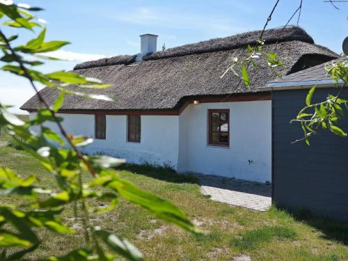 uma casa branca com um telhado de palha e um quintal em 6 person holiday home in Vesl s em Øsløs