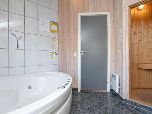 baño con bañera blanca y puerta en 7 person holiday home in Thisted, en Klitmøller