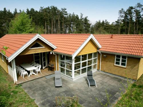 a house with an orange roof and a patio at Lovely Cottage in Aakirkeby with Sauna in Vester Sømarken