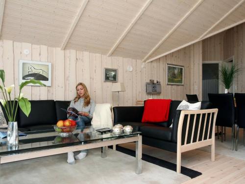 a woman sitting on a couch in a living room at Luxury Retreat in Marielyst - By Traum Ferienwohnungen in Bøtø By