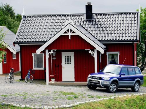 a blue truck parked in front of a red house at 6 person holiday home in Vevelstad in Vevelstad