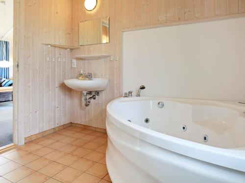 La salle de bains est pourvue d'une baignoire blanche et d'un lavabo. dans l'établissement Two-Bedroom Holiday home in Otterndorf 4, à Otterndorf