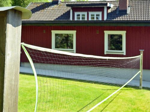 a tennis net in front of a red building at 17 person holiday home in MELLERUD-By Traum in Dals Rostock