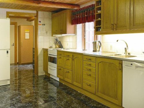 a kitchen with wooden cabinets and white appliances at 17 person holiday home in MELLERUD-By Traum in Dals Rostock