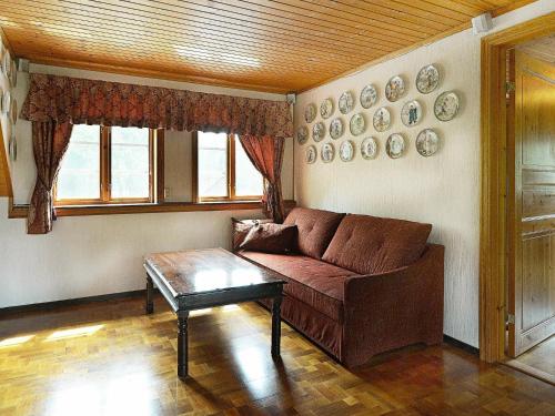 a living room with a brown couch and plates on the wall at 17 person holiday home in MELLERUD-By Traum in Dals Rostock
