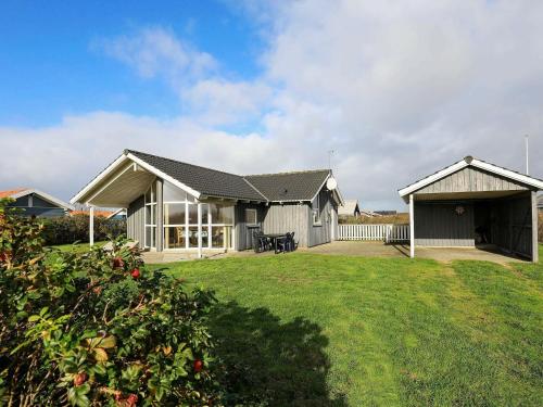a white house with a porch and a yard at 6 person holiday home in Harbo re in Harboør
