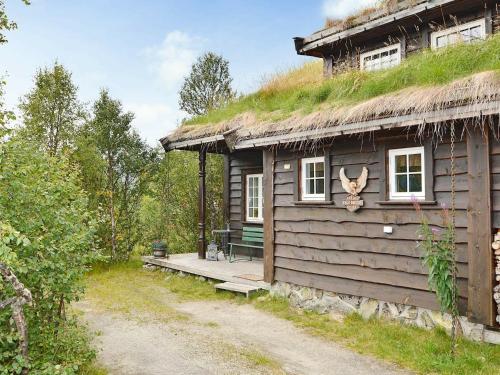 uma cabana de madeira com um telhado de relva e um banco no exterior em 10 person holiday home in HOVDEN em Hovden