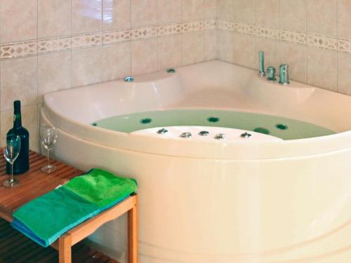 uma grande banheira numa casa de banho com uma garrafa de vinho em 10 person holiday home in HOVDEN em Hovden
