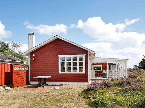 een rood huis met een picknicktafel ervoor bij 6 person holiday home in lb k in Ålbæk