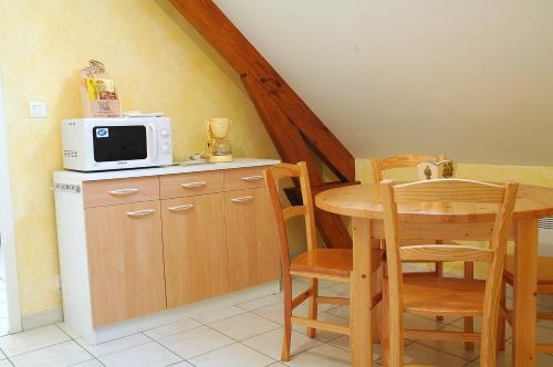 een kleine keuken met een tafel en een magnetron bij Gîtes de Loire in Mosnes