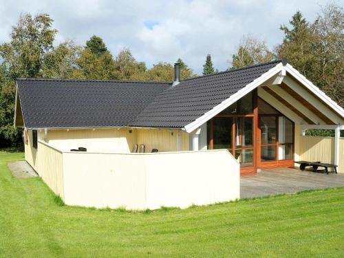 una pequeña casa con una valla delante de ella en 7 person holiday home in Ulfborg, en Sønder Nissum