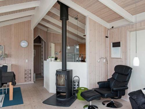 a living room with a stove and two chairs at 8 person holiday home in Ebeltoft-By Traum in Ebeltoft