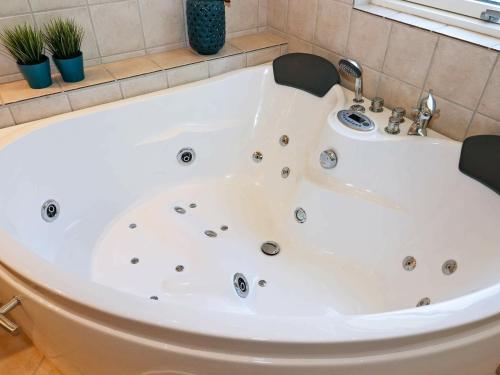 a large white bath tub in a bathroom at 6 person holiday home in Hadsund in Odde