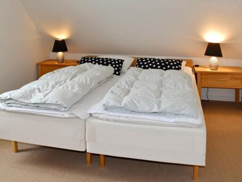 two twin beds in a room with two lamps at Holiday Home Horns Bjerge IV in Blåvand