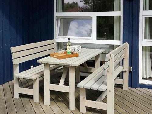 a picnic table and two chairs on a porch at 6 person holiday home in Otterndorf in Otterndorf