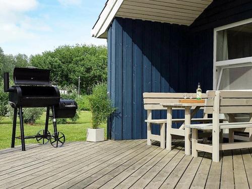 einen Grill auf einer Terrasse mit einem Picknicktisch und einem Grill in der Unterkunft 6 person holiday home in Otterndorf in Otterndorf