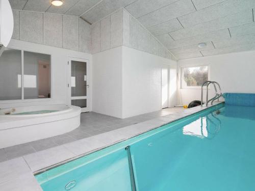 a large bathroom with a swimming pool and a tub at 12 person holiday home in Vejers Strand in Vejers Strand