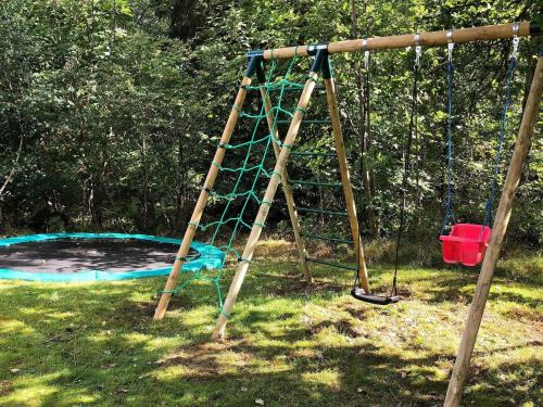 a ladder swing in a yard with a trampoline at 6 person holiday home in Silkeborg in Engesvang