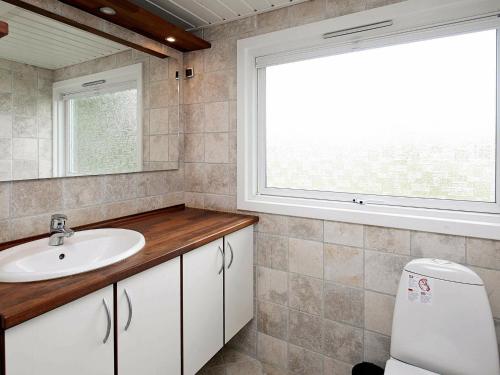 bagno con lavandino, finestra e servizi igienici di Four-Bedroom Holiday home in Jerup 2 a Jerup