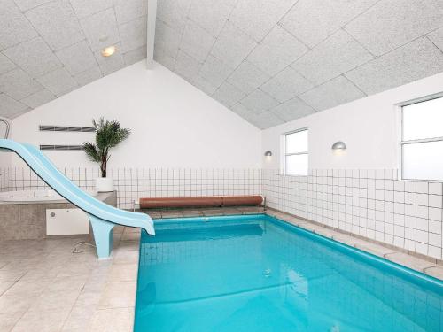 einen Pool mit blauer Rutsche in einem Zimmer in der Unterkunft 16 person holiday home in L kken in Nørre Lyngby