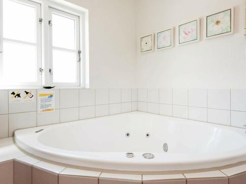 a white bath tub in a bathroom with a window at Modern Cottage in Blavand Jutland with Sauna in Blåvand