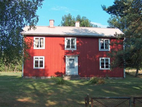 ein rotes Haus mit einer weißen Tür im Hof in der Unterkunft 4 person holiday home in BRUA KULLA in Källekulla