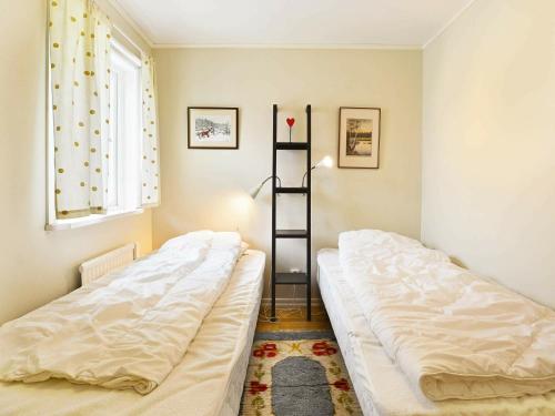 two beds in a room with a shelf at Two-Bedroom Holiday home in Hallabro 3 in Hallabro