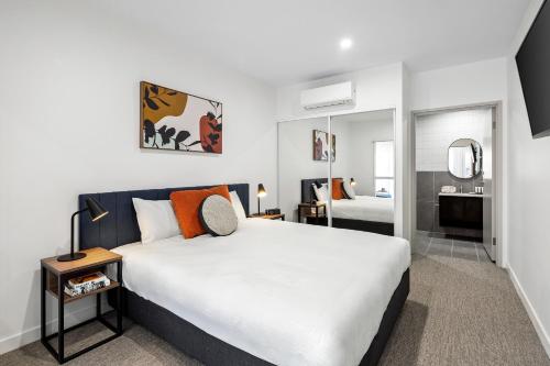 a bedroom with a large bed and a bathroom at Quest Wangaratta in Wangaratta