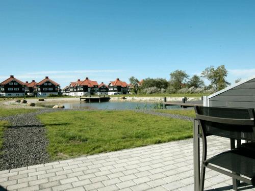 ボーゲンセにある4 person holiday home in Bogenseの家屋が並ぶ川の横に座るベンチ