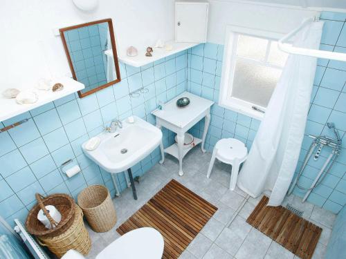 ロッケンにあるTwo-Bedroom Holiday home in Løkken 12の青いタイル張りのバスルーム(シンク、鏡付)