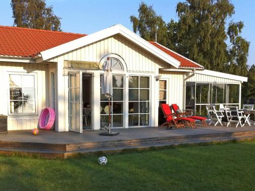een huis met een terras en stoelen in de tuin bij 5 person holiday home in RONNEBY in Ronneby