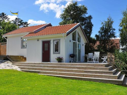 Cette petite maison blanche est accessible par des escaliers. dans l'établissement 4 person holiday home in STENUNGSUND, à Stenungsund