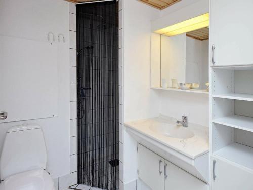 biała łazienka z toaletą i umywalką w obiekcie Holiday Home Golfvejen II w mieście Fanø