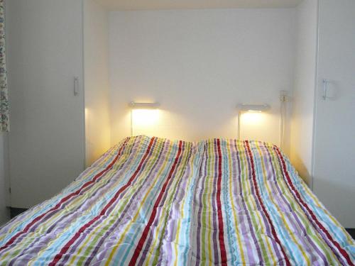 Una cama con una manta de colores en una habitación en Holiday Home Golfvejen II, en Fanø