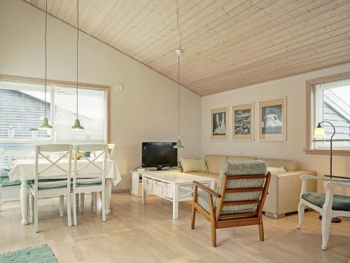 sala de estar con mesa y TV en 4 person holiday home in Gudhjem, en Gudhjem