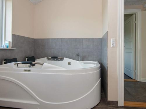 a large white tub in a bathroom with a wall at 8 person holiday home in Ansager in Ansager