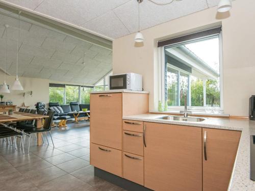 a kitchen with a sink and a table with chairs at 8 person holiday home in Ansager in Ansager