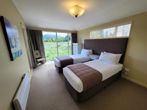 a hotel room with two beds and a window at Mantra Lake Tekapo in Lake Tekapo