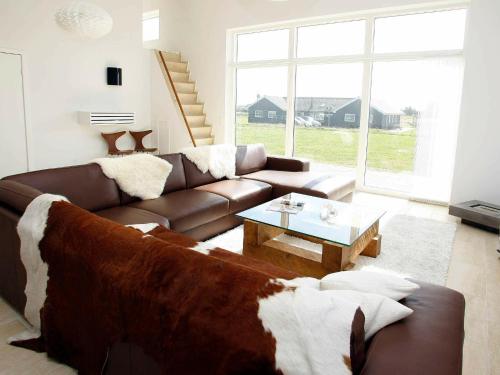 uma sala de estar com um sofá castanho e uma mesa em Five-Bedroom Holiday home in Løkken 3 em Lokken