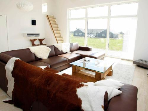 a living room with a brown couch and a table at 18 person holiday home in Løkken-By Traum in Løkken