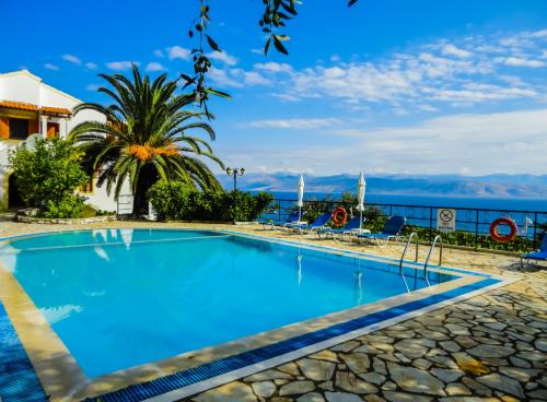 a swimming pool with a view of the ocean at Dionysos Apartments in Apraos