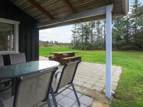 un patio con mesa, sillas y mesa de picnic en 6 person holiday home in S by en Sæby